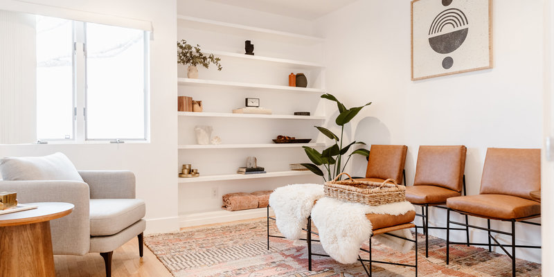 A cozy seating area with modern decor, soft lighting, leather chairs, and a patterned rug, creating a warm and inviting atmosphere.