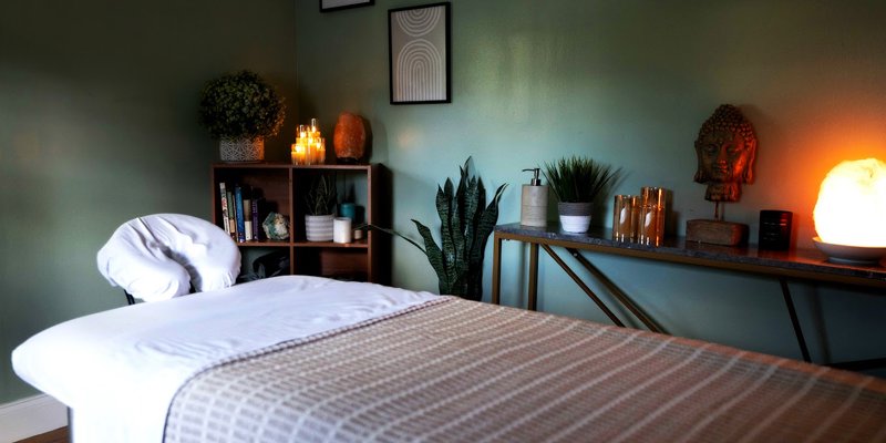 A tranquil massage room with soft lighting, soothing candles, and calming decor, creating a peaceful and relaxing environment.