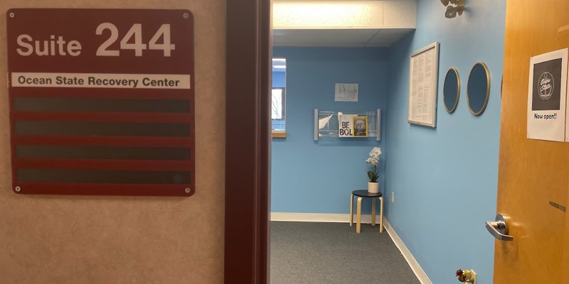 A welcoming entrance to Ocean State Recovery Center, Suite 244, featuring a cozy, well-decorated waiting area with bright blue walls and inspirational decor.