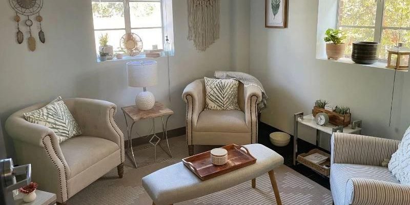  A cozy, sunlit therapy room featuring comfortable armchairs, soft lighting, and calming decor, creating a serene and inviting atmosphere.