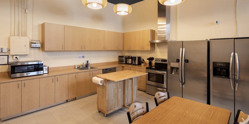  A modern, well-equipped kitchen with stainless steel appliances, ample cabinet space, a center island, and warm, inviting lighting.