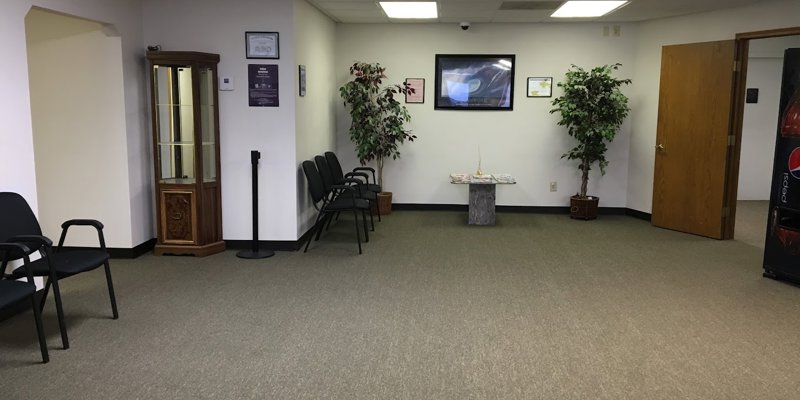 A clean and welcoming waiting area with comfortable seating, plants, and natural lighting, providing a calming and professional atmosphere.