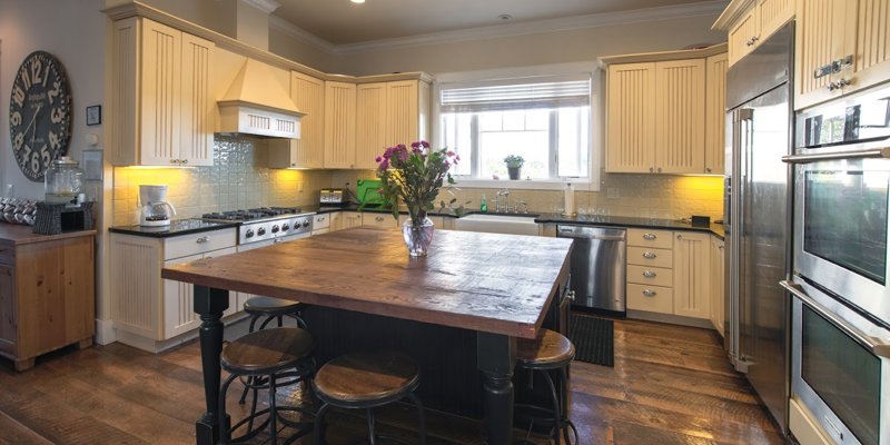 A warm, inviting kitchen with rustic wooden floors, modern appliances, and a large island perfect for gathering and preparing meals.