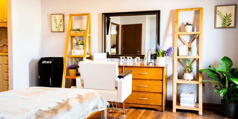 A bright, inviting beauty room with a stylish chair, large mirror, and modern decor, offering a peaceful space for self-care and relaxation.