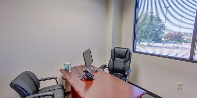  A private office with large windows, natural light, and comfortable seating, creating a welcoming space for confidential conversations.