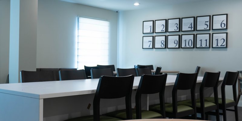 A bright, modern meeting room with ample seating and framed motivational quotes on the wall, fostering a positive and focused atmosphere.