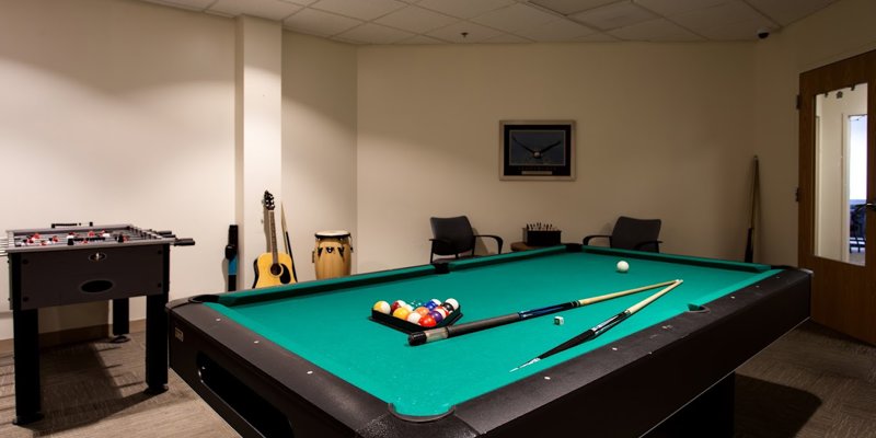 A recreational room featuring a pool table, foosball table, and musical instruments, offering a fun and relaxing space for leisure activities.