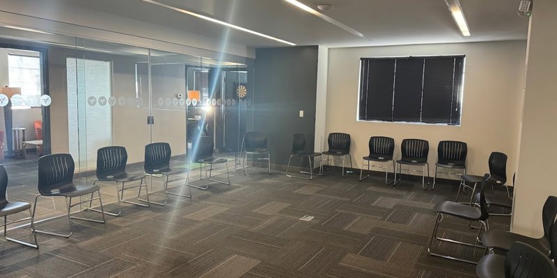 Spacious meeting room with a circle of chairs and natural light, providing an inviting space for group discussions and collaborative sessions.