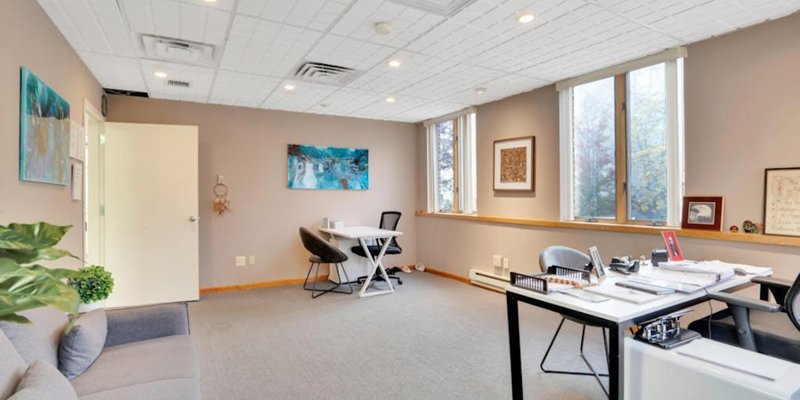 A private office with a desk, a comfortable couch, and modern decor, offering a serene space for one-on-one consultations or therapy sessions.