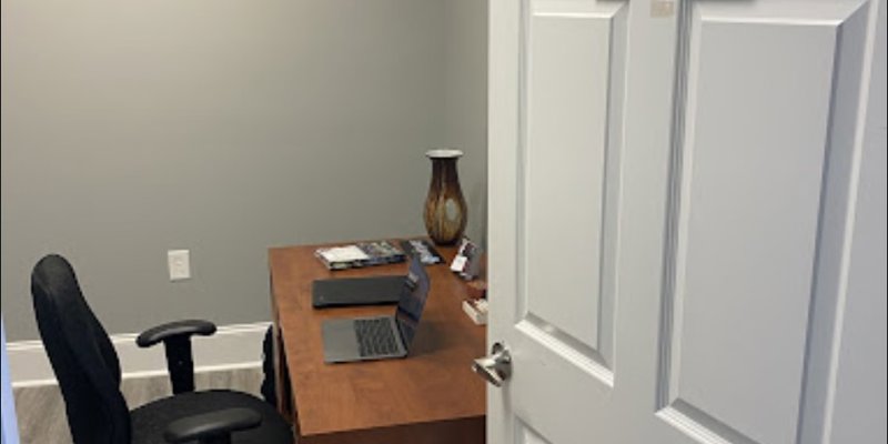 Welcoming office space with a wooden desk, comfortable chair, and soft lighting, creating a professional and calming environment for work.