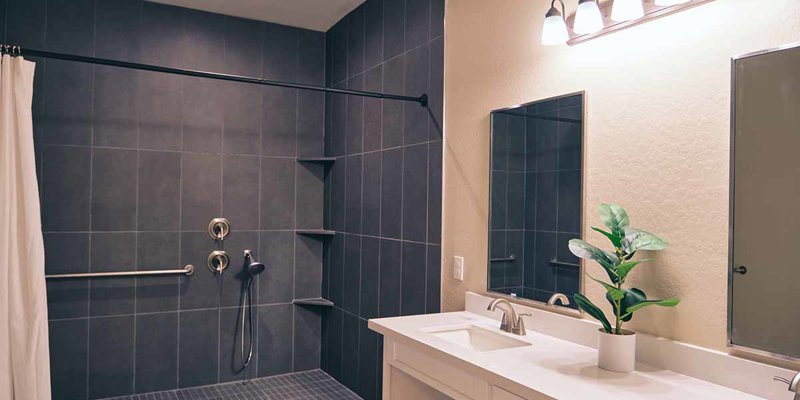 A modern, spacious bathroom with a sleek walk-in shower, double sinks, bright lighting, and a touch of greenery for a refreshing feel.