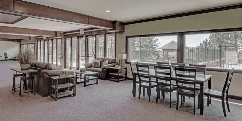 Spacious lounge with comfortable seating, large windows providing natural light, and a dining area perfect for group gatherings and relaxation.