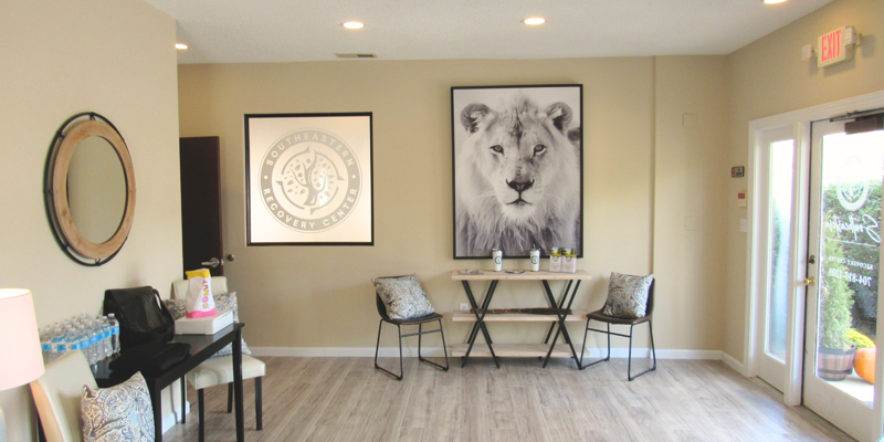 A bright, welcoming lobby with comfortable seating, a striking lion portrait, and warm decor, creating an inviting and peaceful atmosphere.