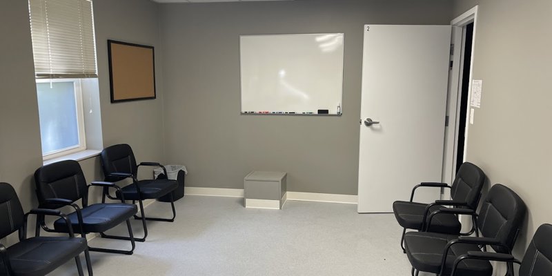 A clean and organized room with rows of chairs and a whiteboard, creating an ideal environment for small group meetings or discussions.