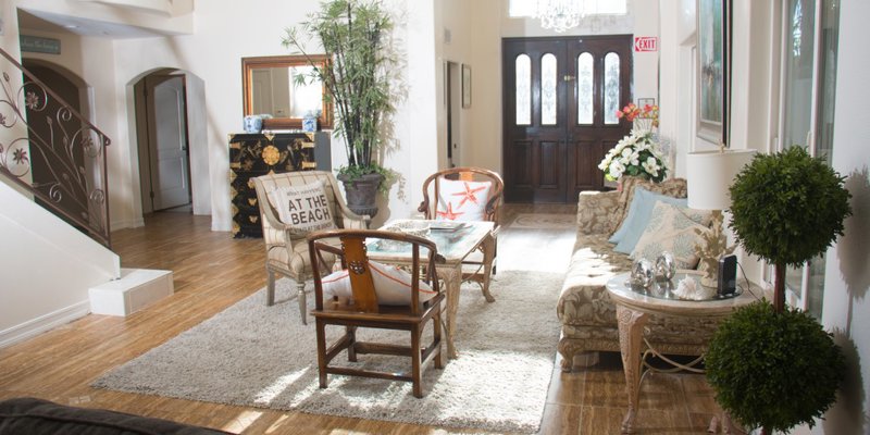 Welcoming entryway with stylish seating, beach-themed décor, and warm lighting, creating a cozy and inviting atmosphere for guests.